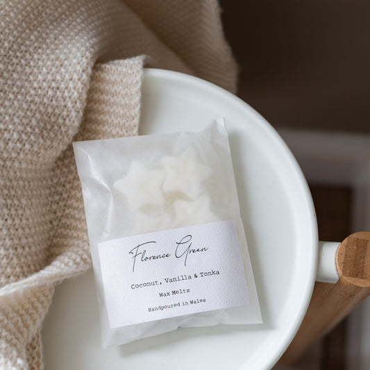 White wax melt packet labeled 'Florence Green' on a white plate with a beige towel.