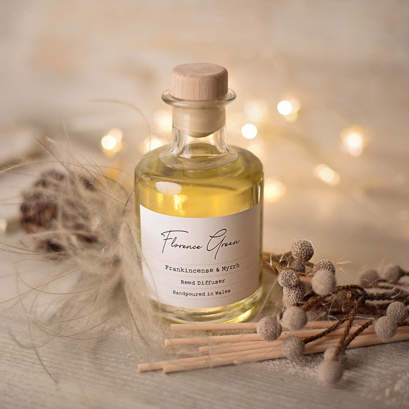 A bottle of Florence Green perfume with a label on a wooden surface with decorative elements.