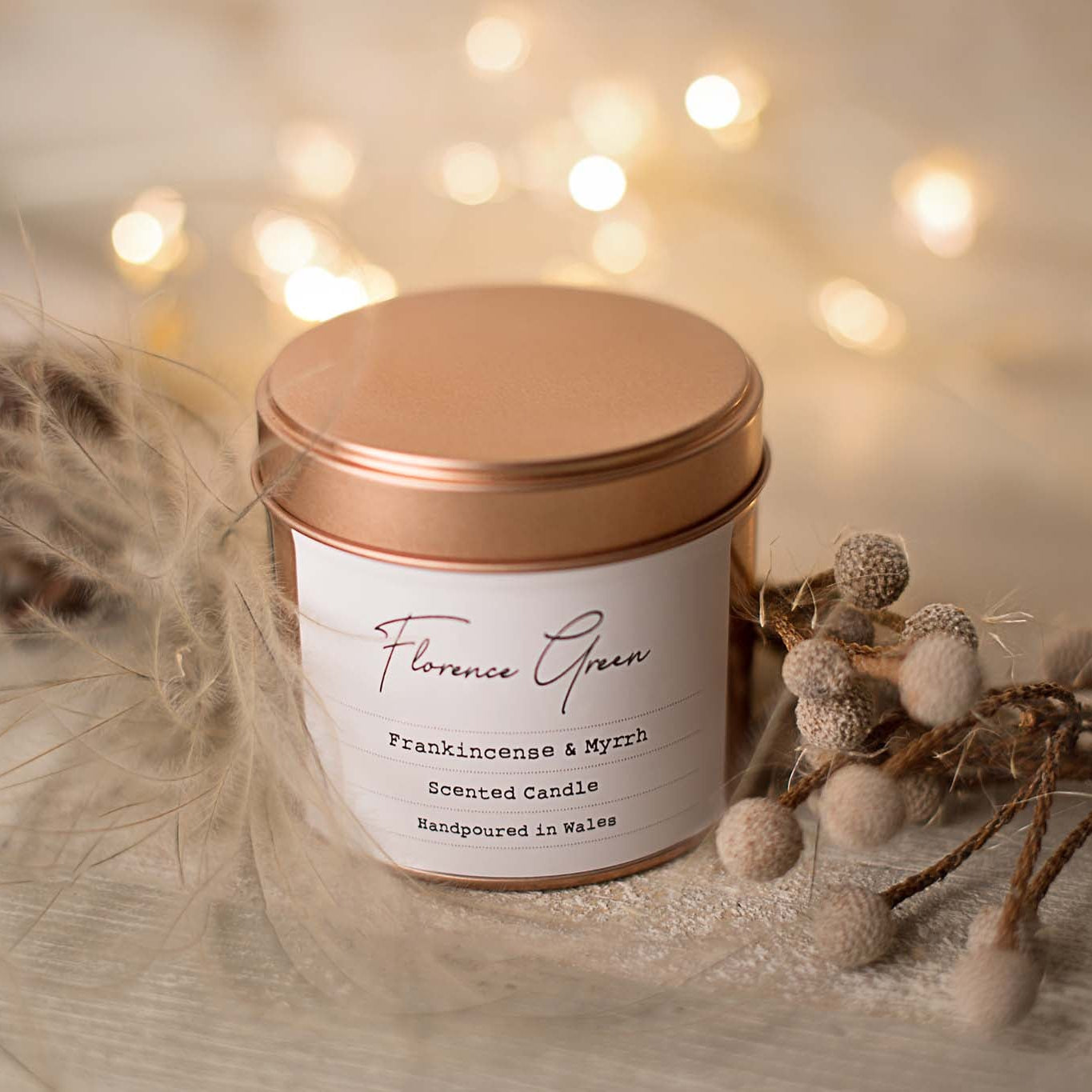 Candle in a copper tin with decorative elements on a soft background