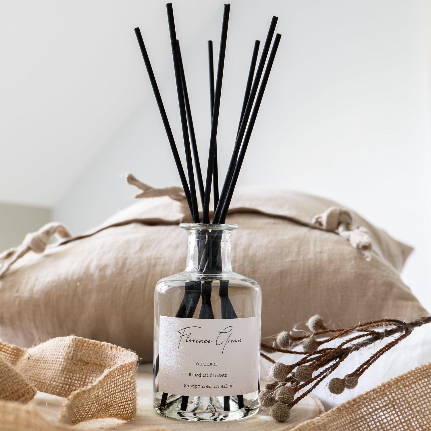 Diffuser bottle with black sticks on a neutral background
