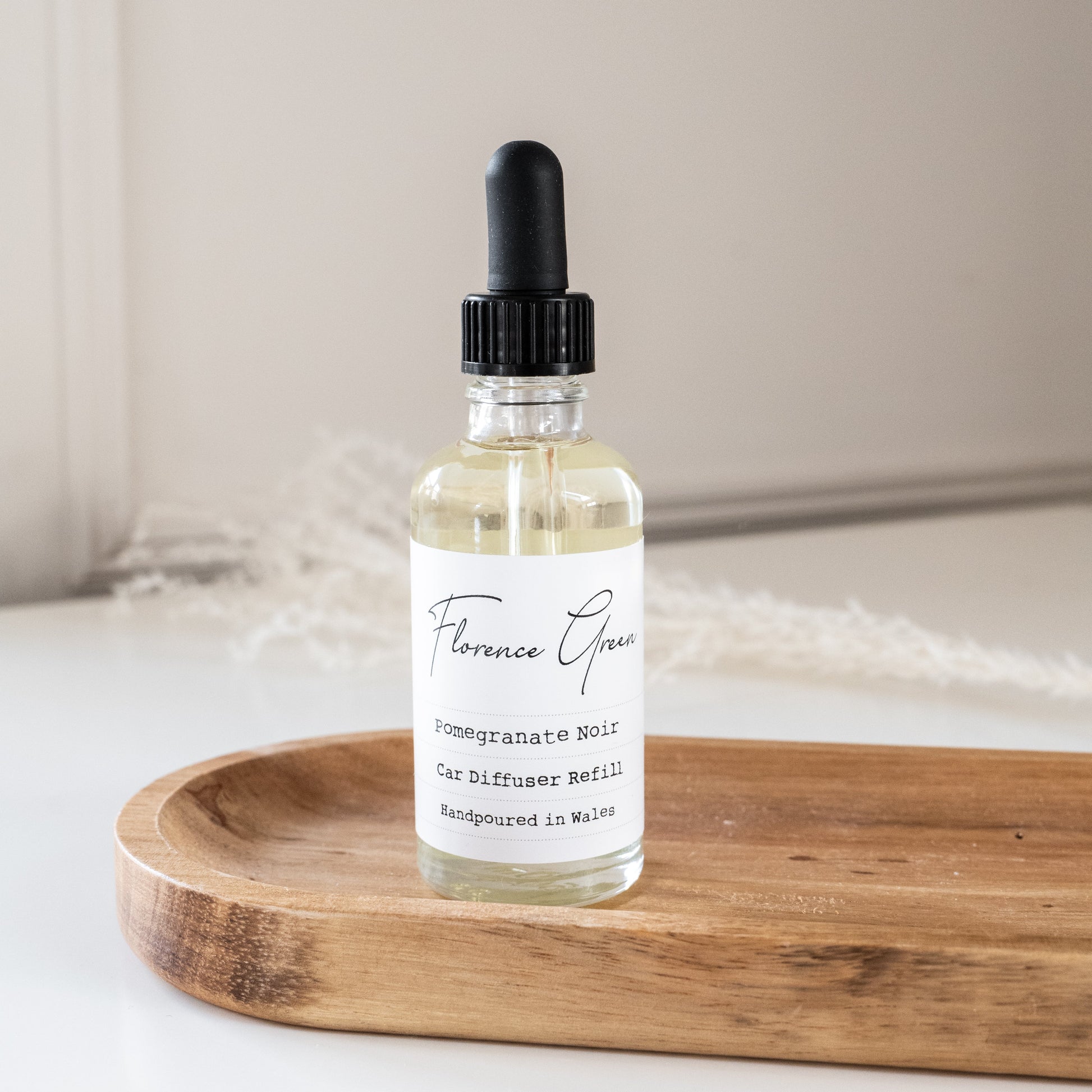 Bottle of Florence Grace diffuser oil on a wooden tray with a neutral background