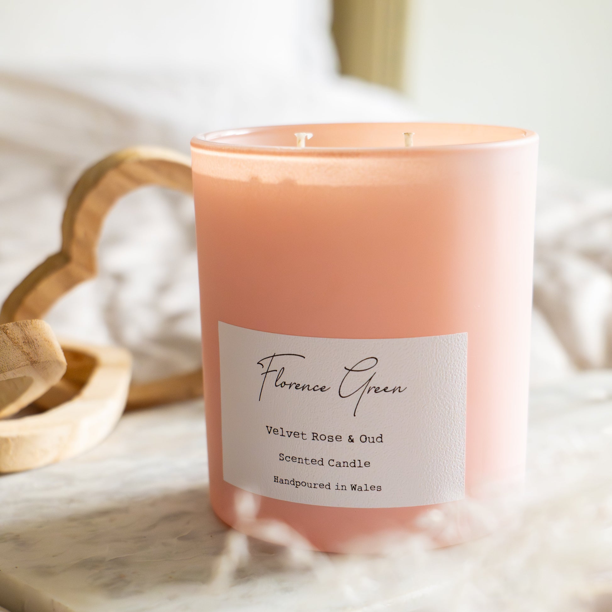 Pink candle with a label on a soft surface
